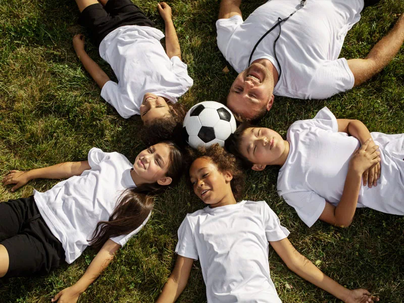 mindful-movements.org-activities-crsl-football-mixed-kids-and-coach-laying-on-grass